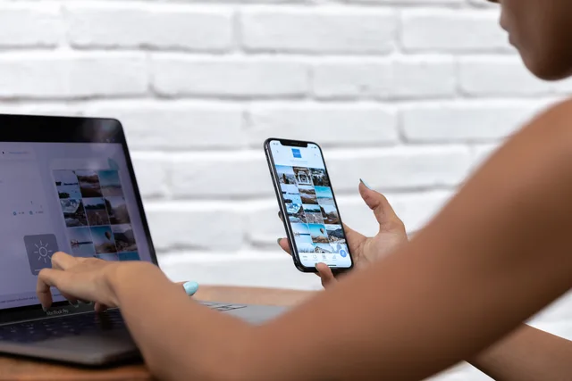 A woman working remotely using a laptop and smartphone, focusing on social media content. How to build social media scheduling buyer personas